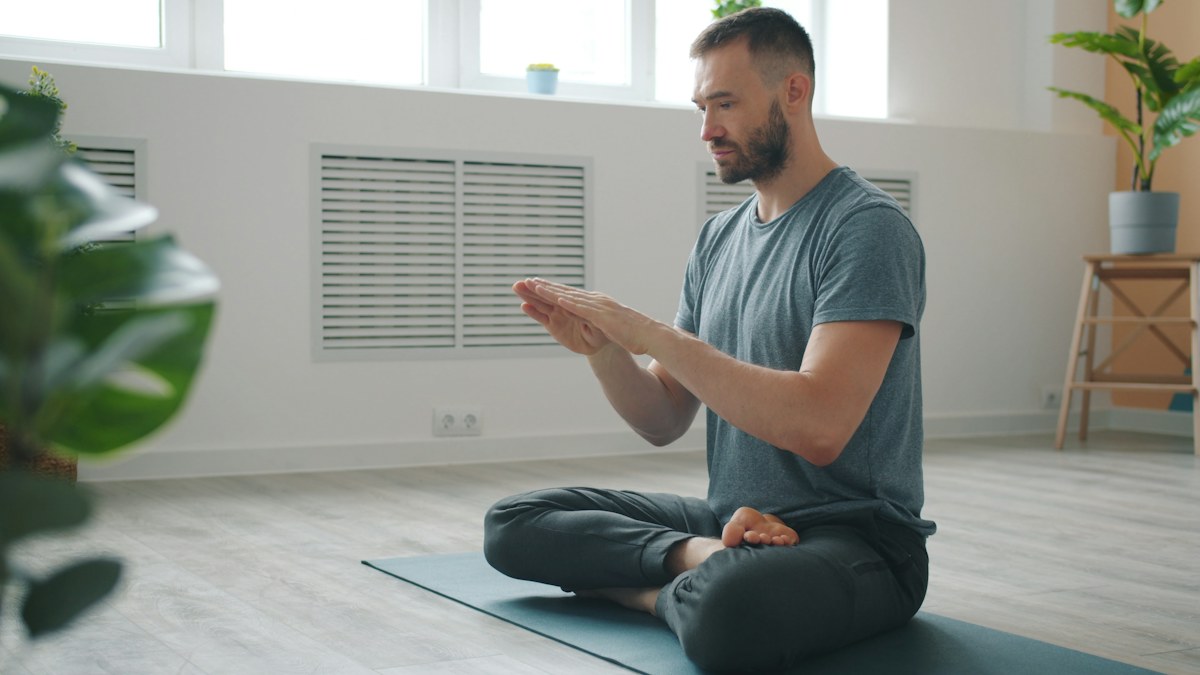 Man practicing relaxation and breathing at home