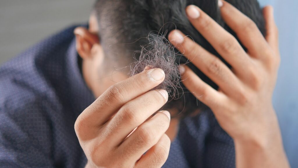 Man checking and arranging his hair as part of a grooming routine