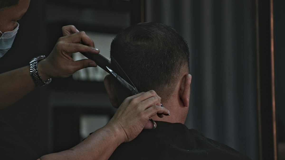 Barber grooming a man's hair