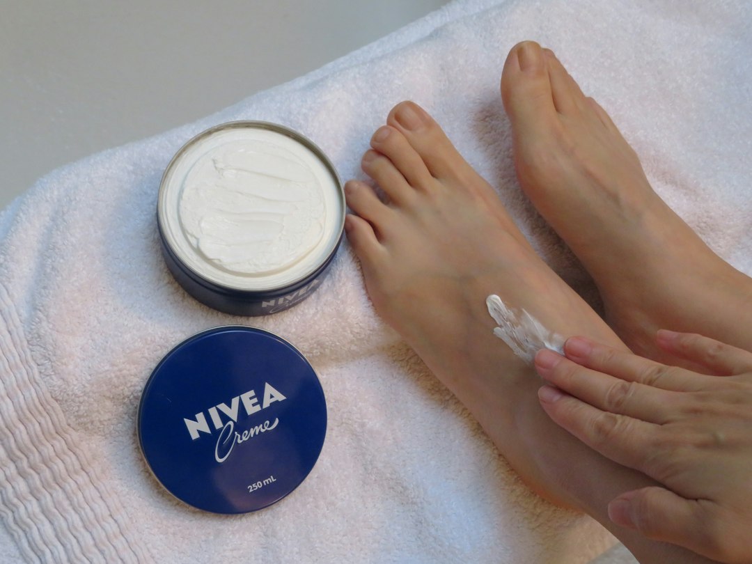 Moisturizer being applied to dry foot skin