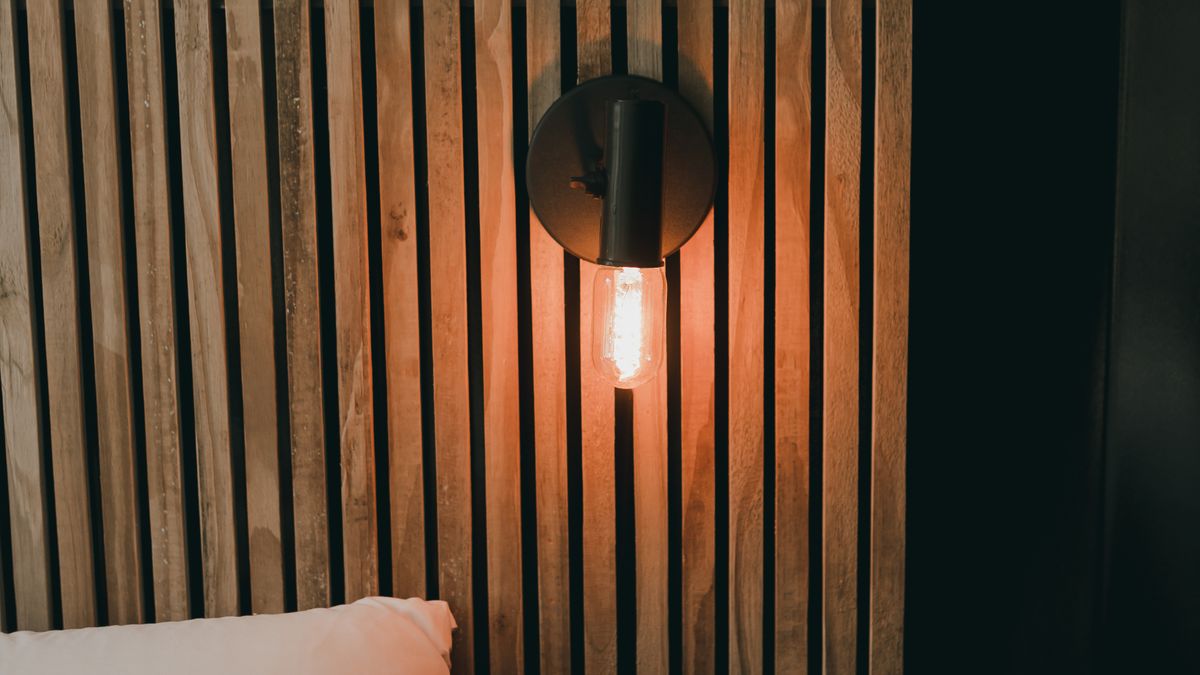 Vertical wooden slats form a textured bedroom feature wall