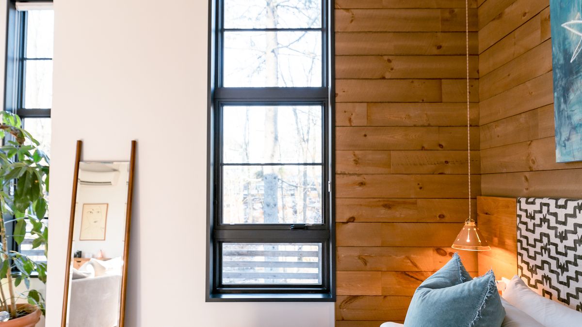 A bedroom with warm wood accent paneling, illustrating a natural-oak wall treatment