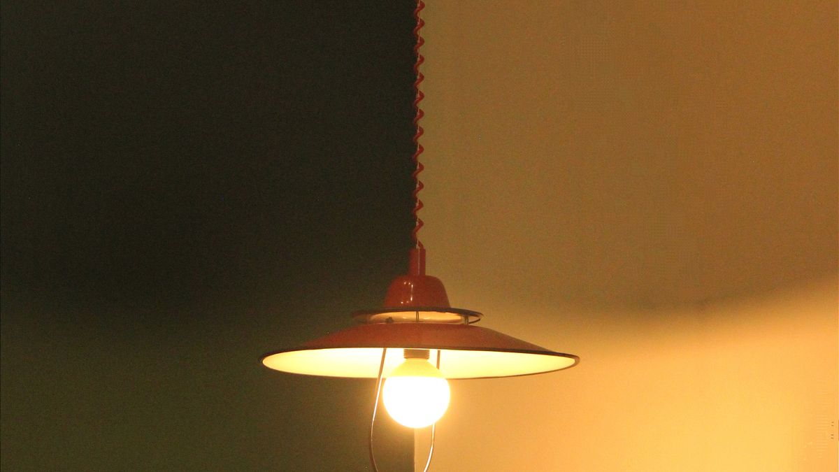 A vintage wall lamp against contrasting paint colors on a two-tone wall