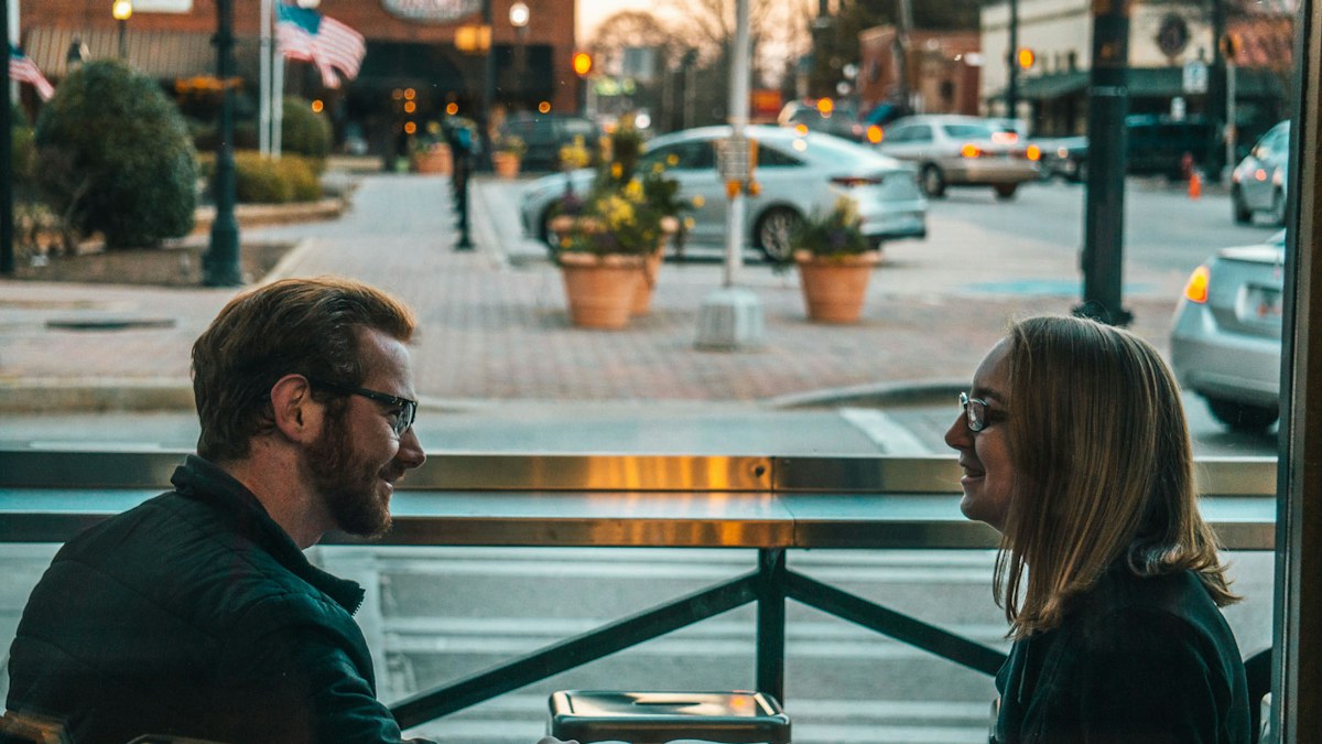 Man and woman talking at a table in a cafe