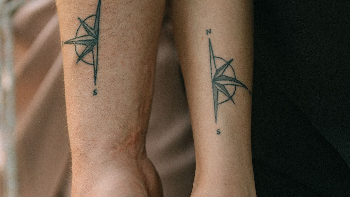 A small compass design tattooed on a forearm