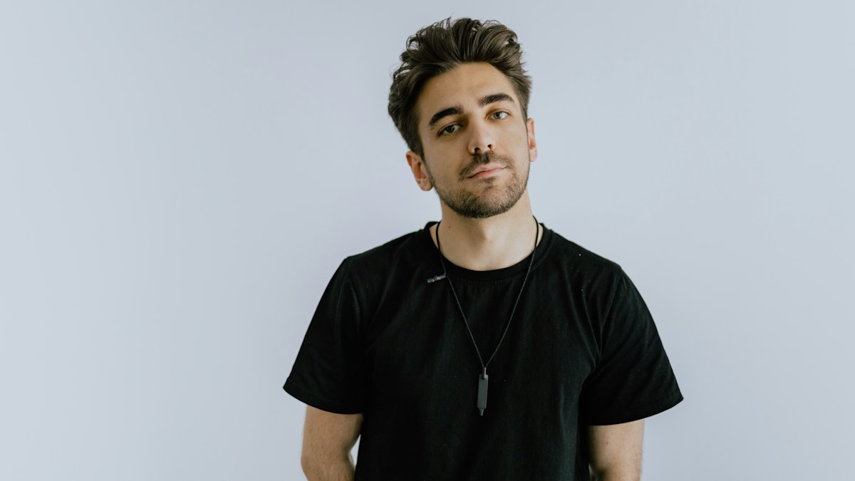 Man wearing a plain black T-shirt in a casual setting