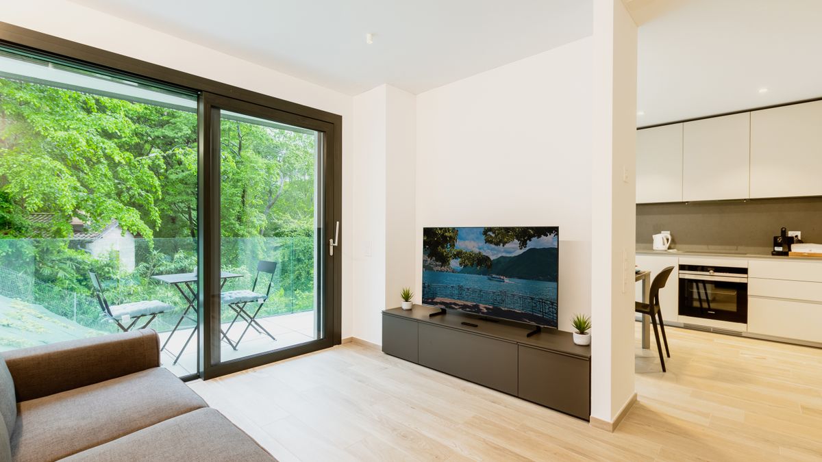 A compact gray sofa in a small, open-plan living room