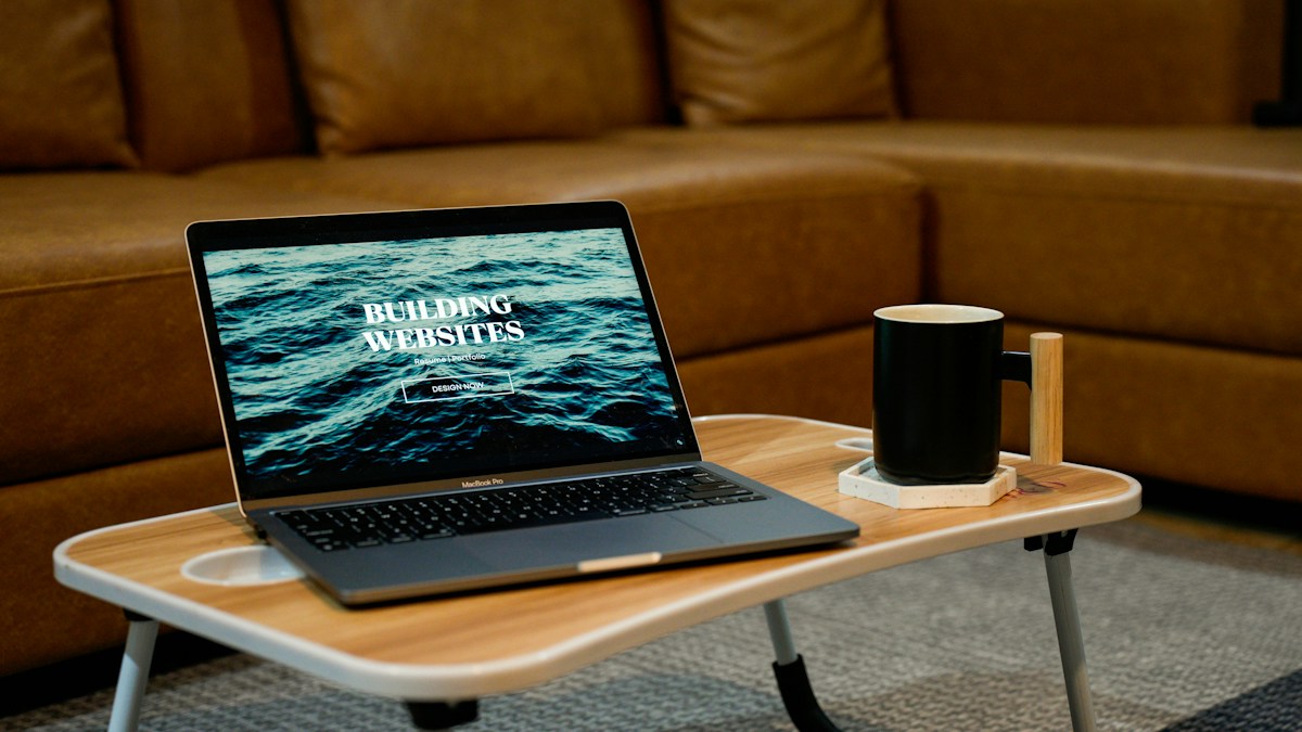 Laptop on a portable small work table with a mug nearby
