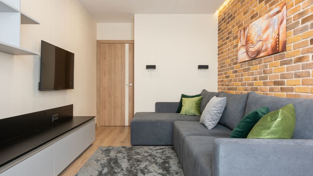 A modest media wall and wall-mounted television keep a living room organized