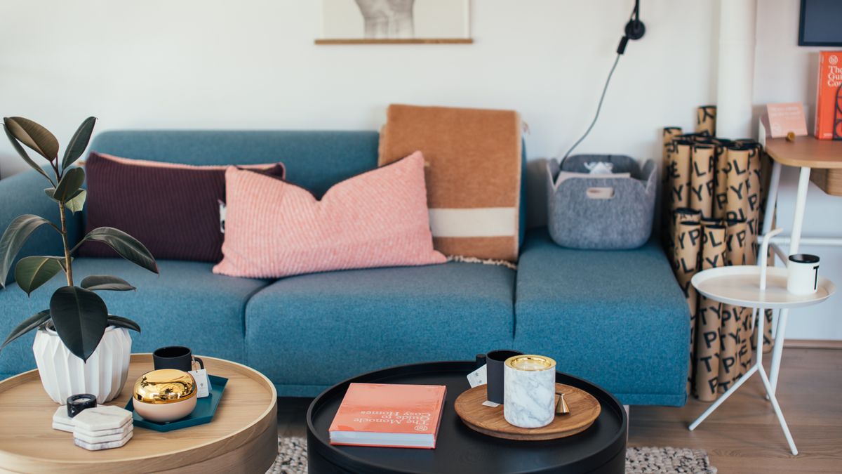 A compact living room with a blue sofa and round coffee tables