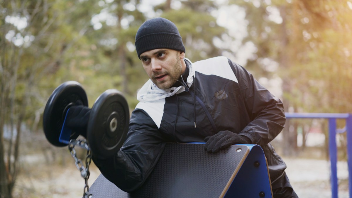 Man lifting a barbell outdoors