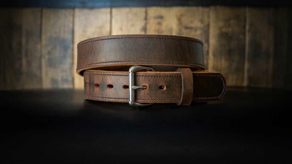 Leather belt arranged on a dark surface