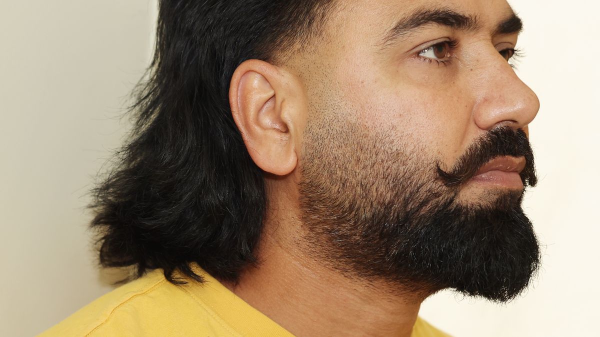 Side profile of a bearded man in a yellow shirt