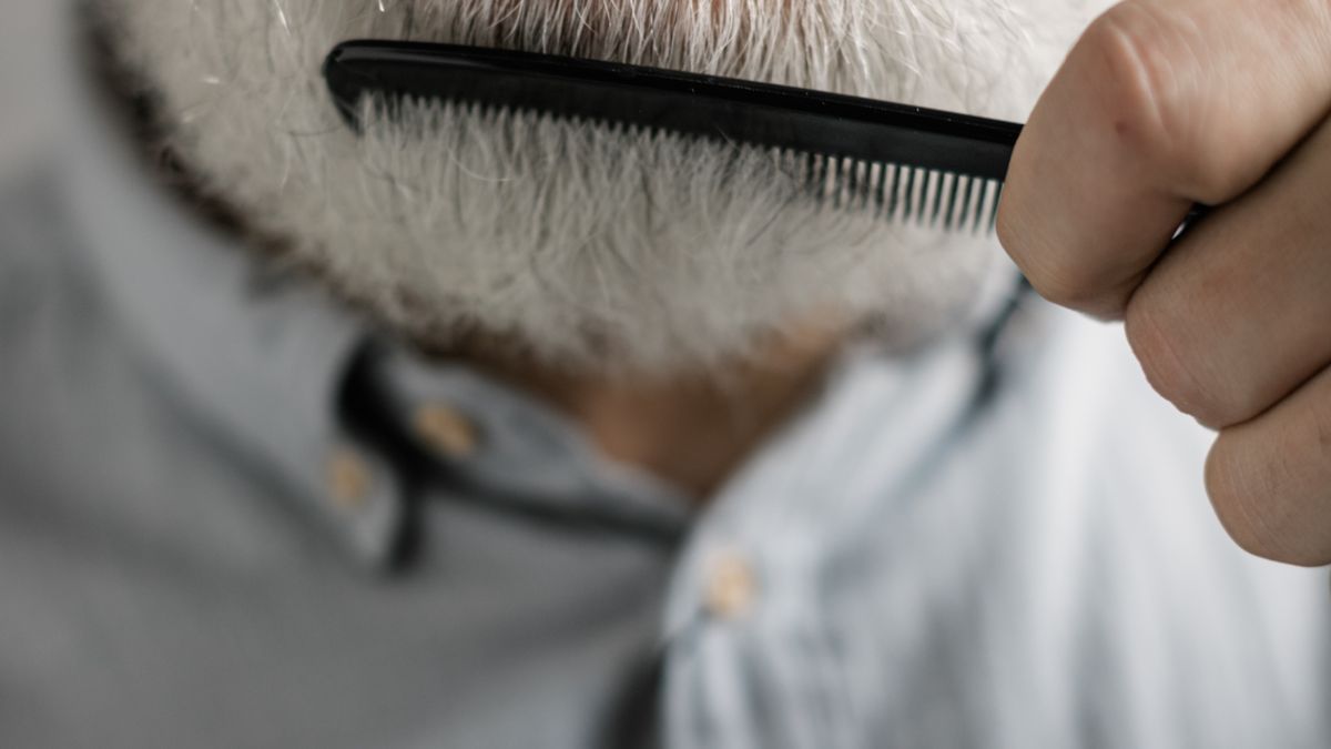 Small wooden beard comb on weathered wooden table