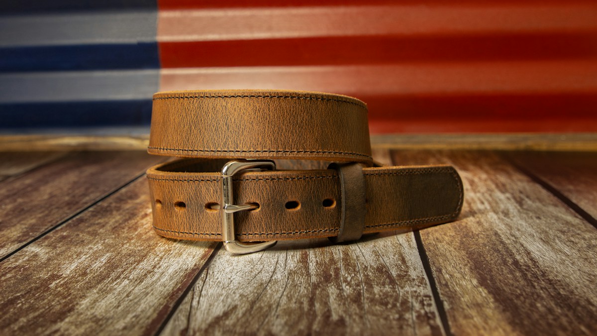 Brown leather belt on wood