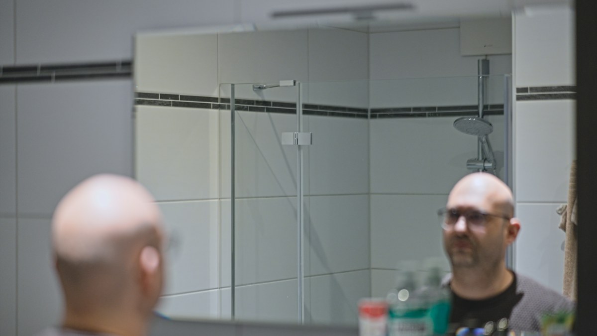 Man reflected in a bathroom mirror