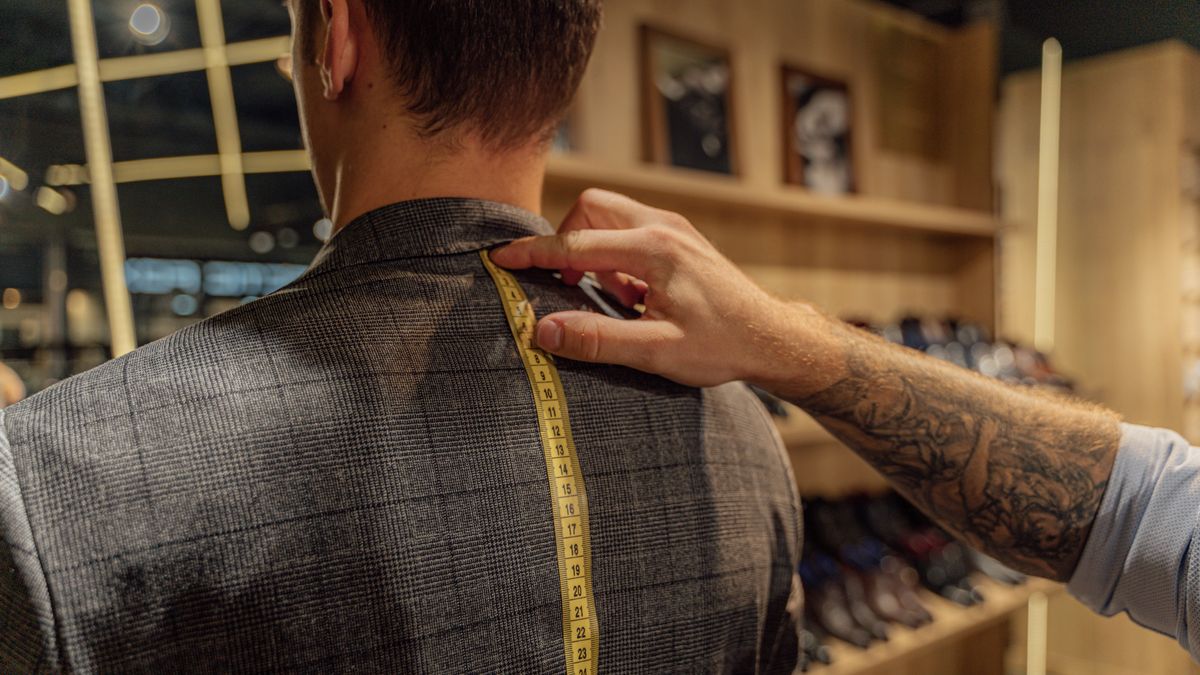 Tailor measuring the shoulder on the back of a men's jacket