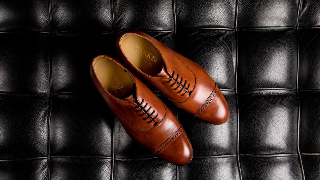 Pair of black lace-up dress shoes on a plain background
