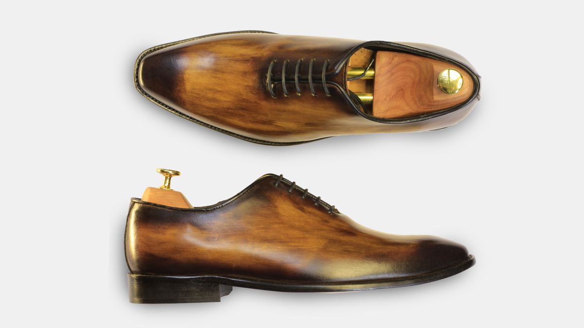 Traveler packing shoes and clothing into suitcase compartments