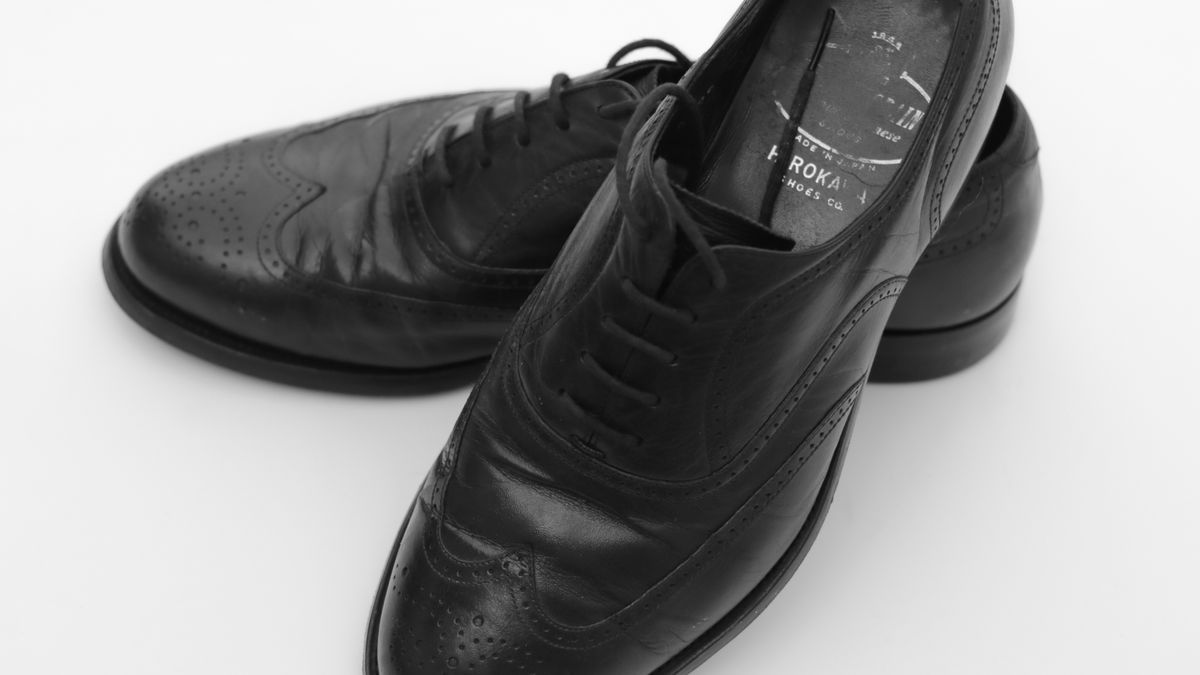 Tan men's dress shoes showing side profiles and soles