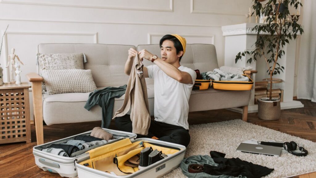 Man arranging business-trip clothing in a suitcase.