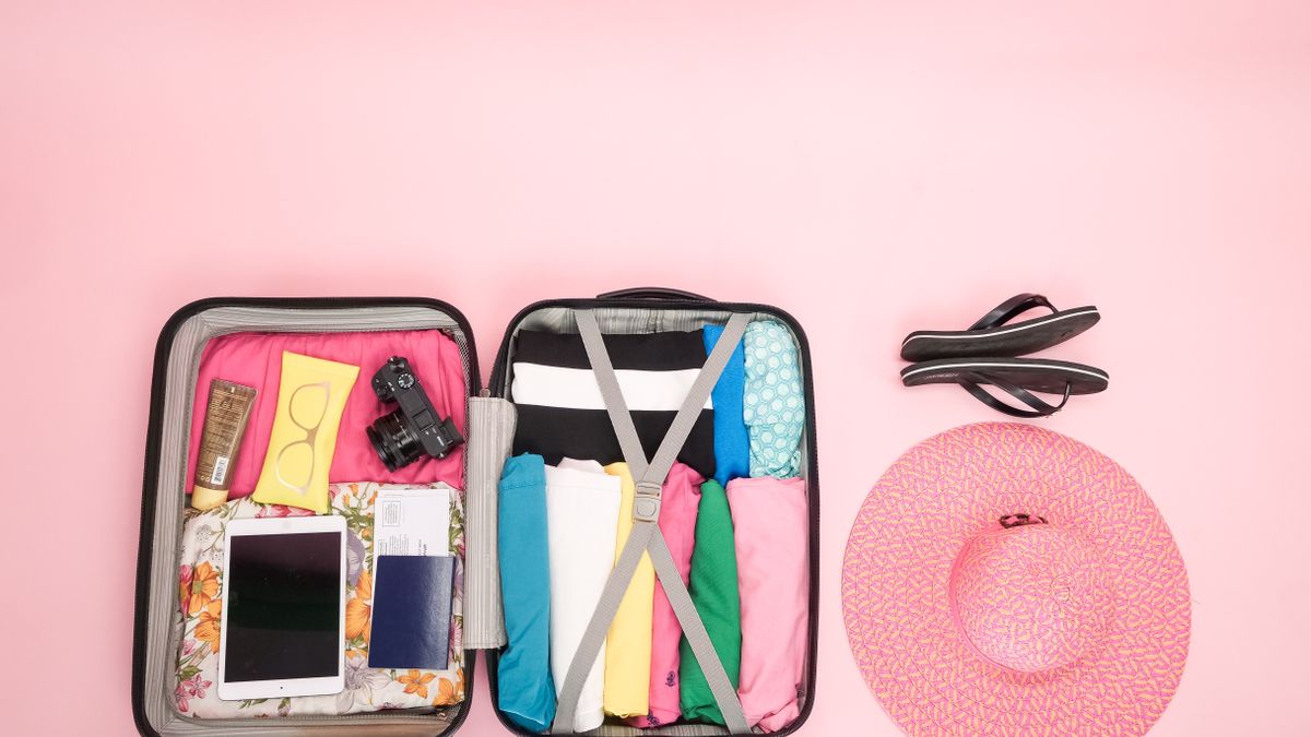 Open suitcase organized with summer clothing.