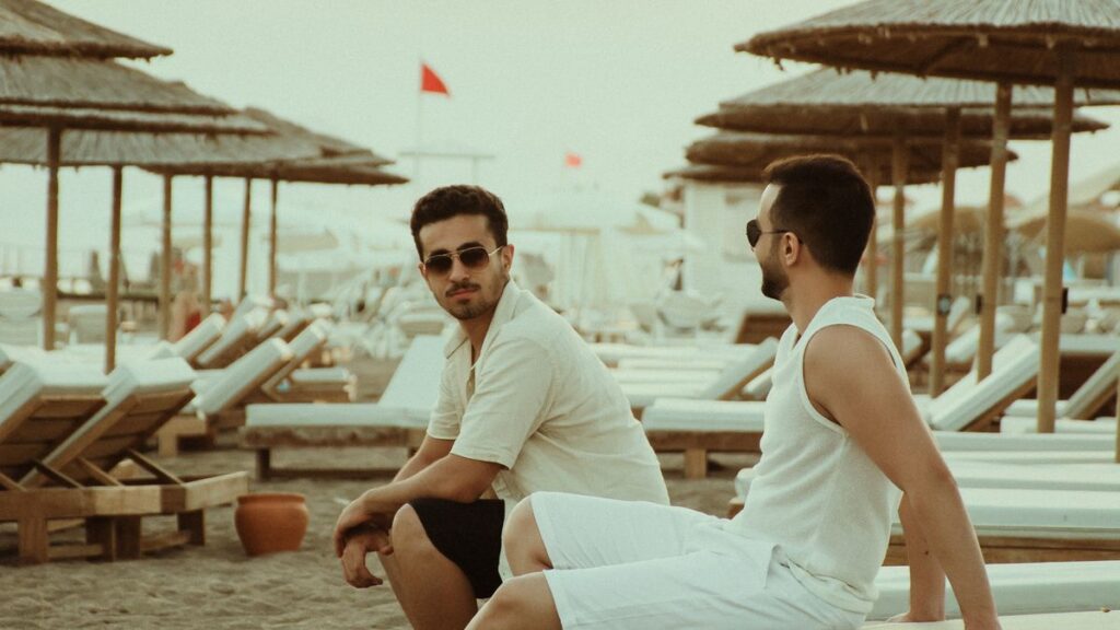 Two men relaxing on beach sunbeds.