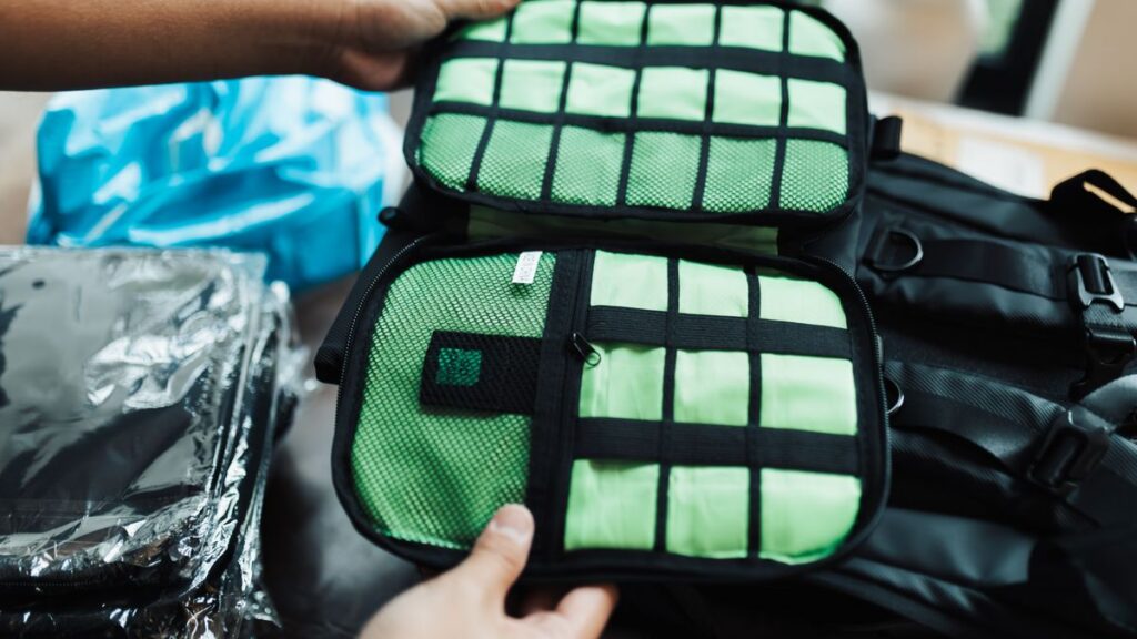 Hands organizing packing cubes inside a travel bag.