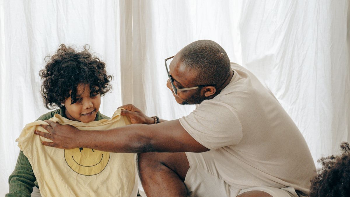 Father organizing clothing and luggage with children.