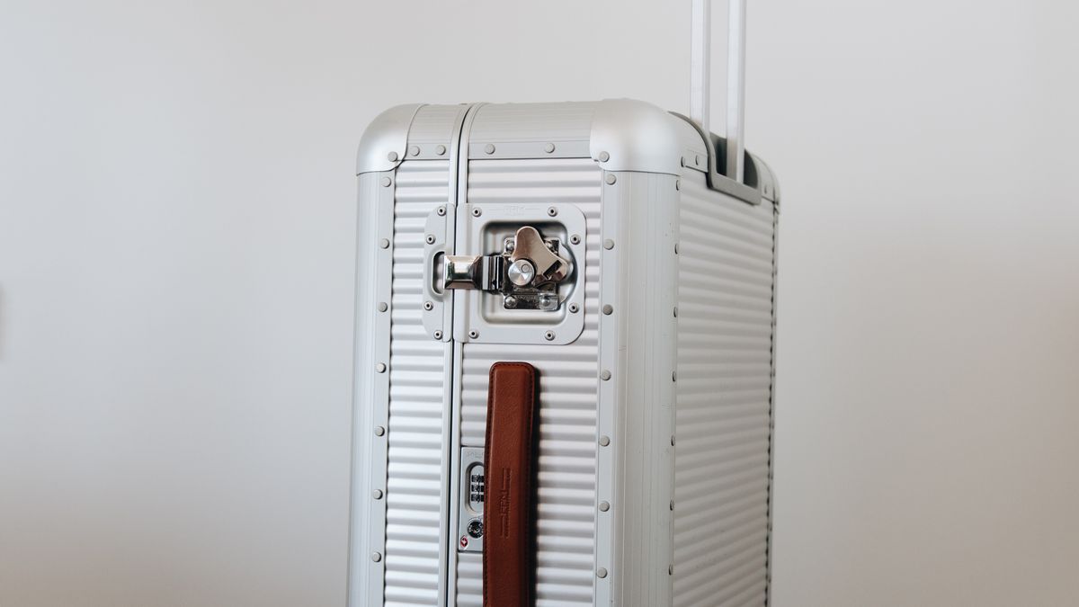 Black sneakers beside a compact silver travel case.