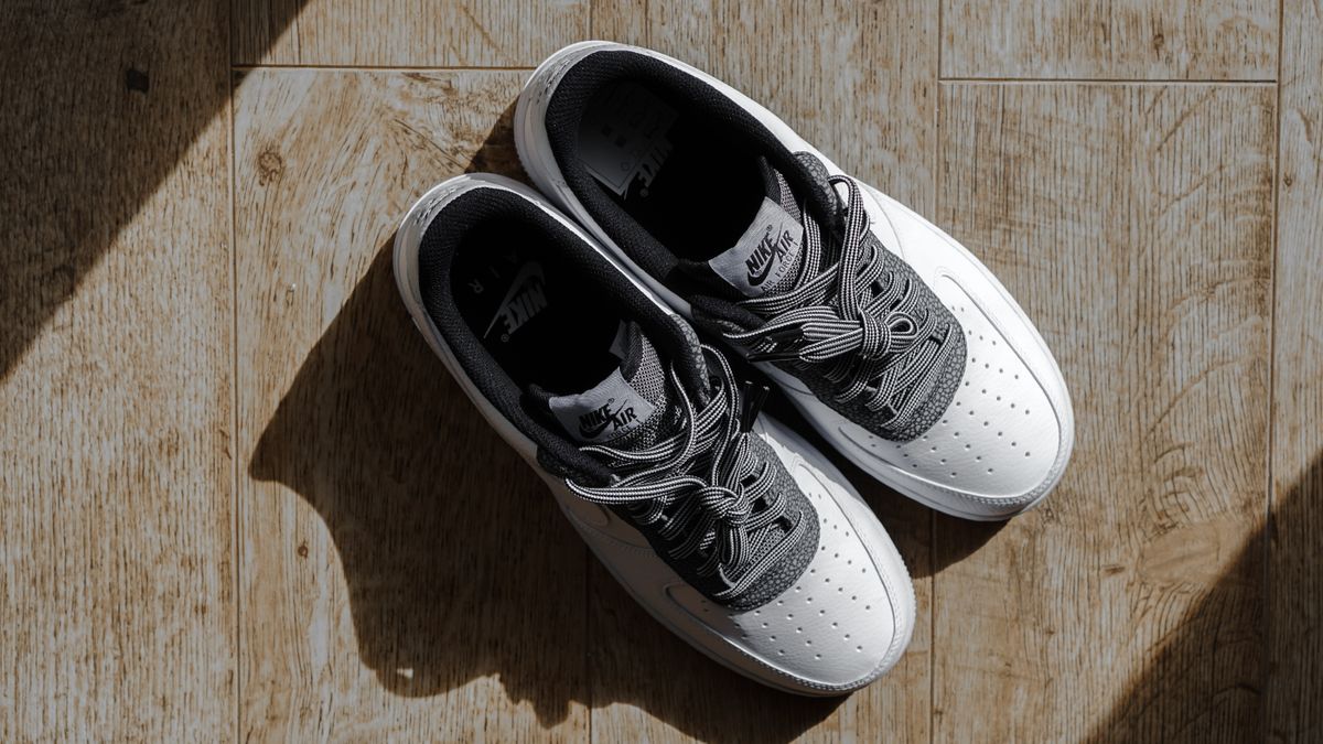 White and gray sneakers on wooden floor.