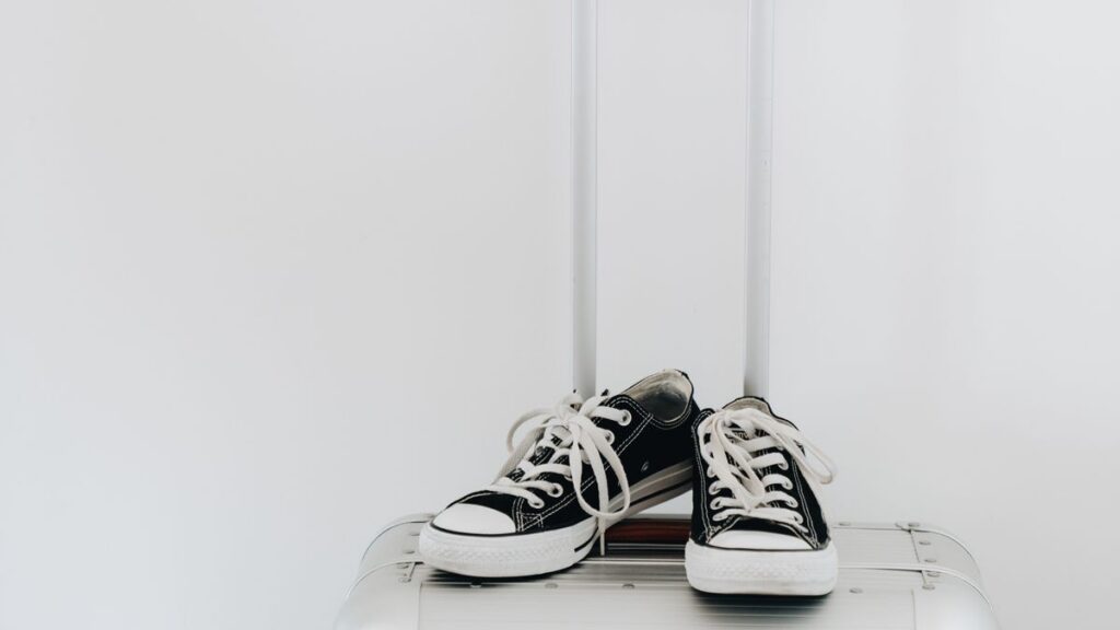 Canvas sneakers resting on a travel suitcase.