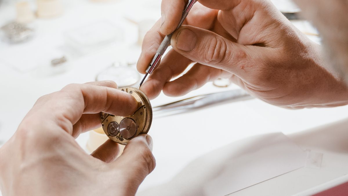 Watch technician working on movement with a screwdriver
