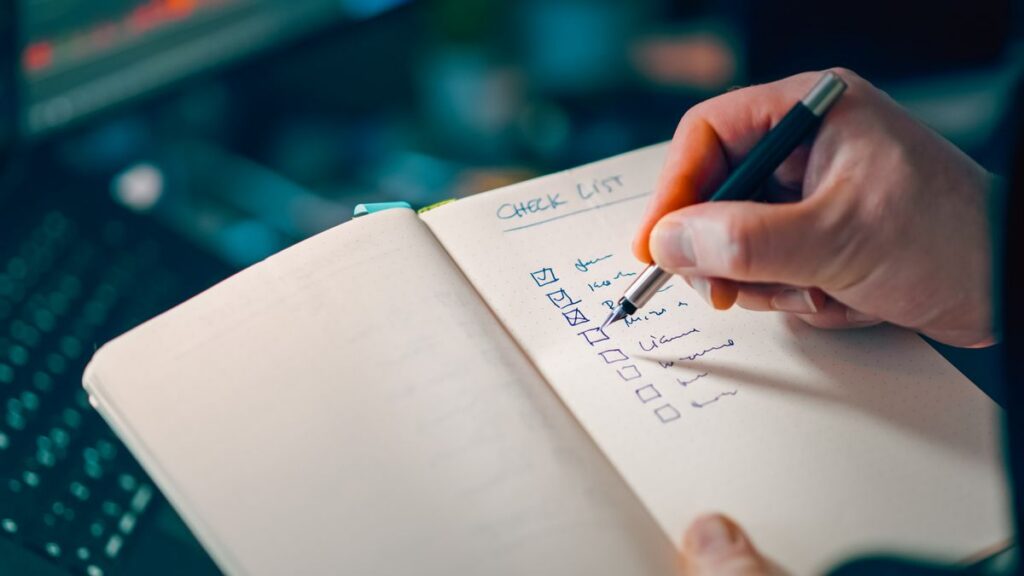 Hand checking boxes on a notebook list