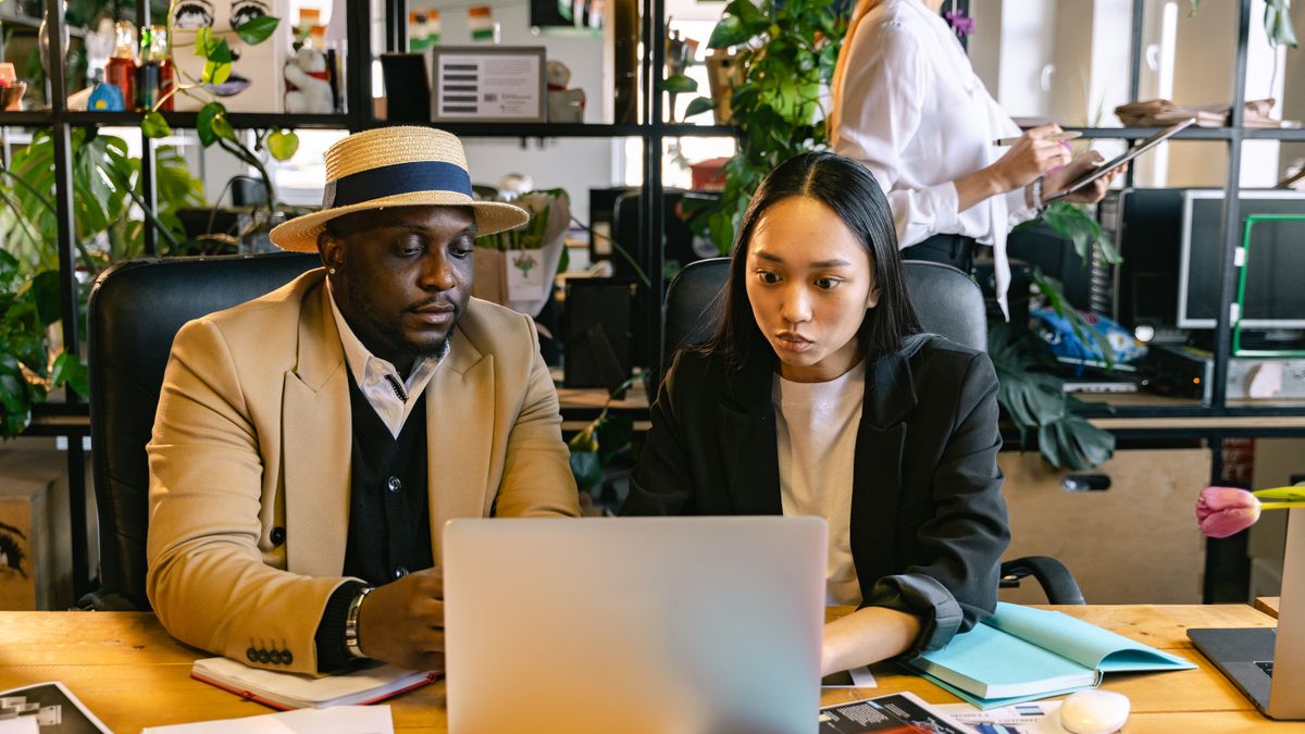 Colleagues reviewing work together at a laptop