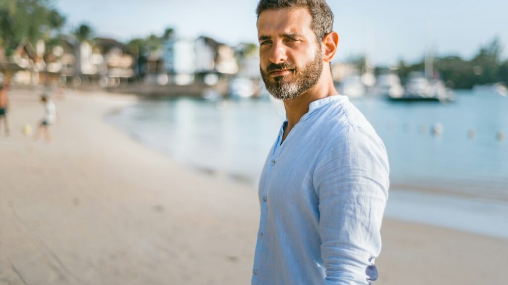 Middle aged man standing outdoors by the water