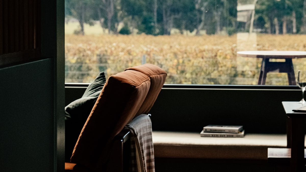 A compact chair beside a large window illustrates a one-seat reading retreat