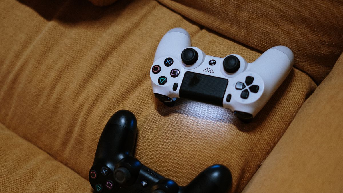 Game controllers on a sofa illustrate a compact console corner
