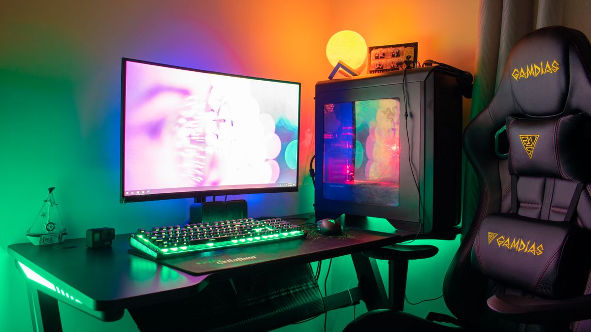An RGB-lit PC gaming desk in a dedicated corner