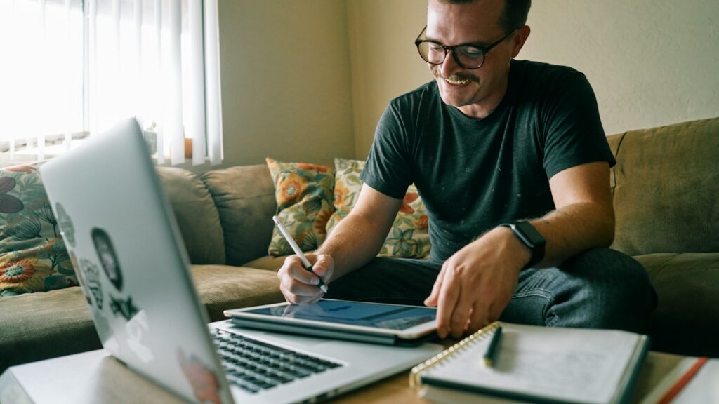 Man reviewing documents while working at a laptop