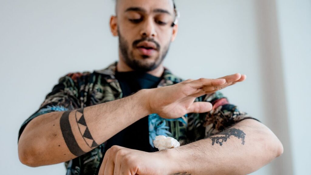Man tending to tattooed skin on his forearm