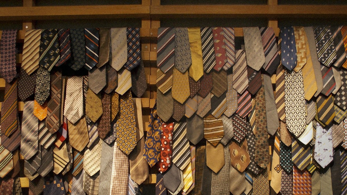 Selection of neckties hanging on a rack illustrating tie length and style options