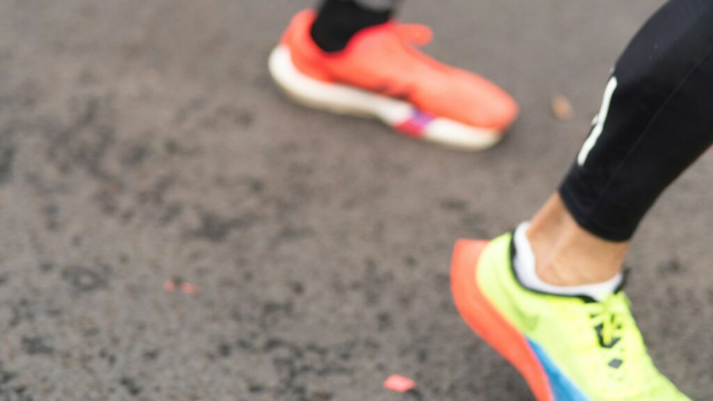 Runners wearing athletic shoes on pavement, featured image for running shoe replacement guide