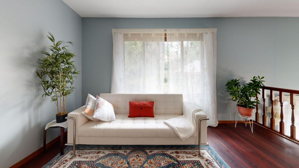 Bright living room with a white sofa, potted plants and natural light