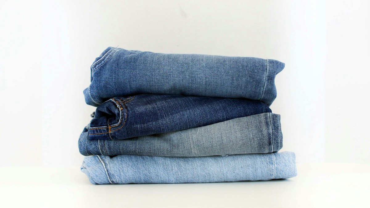 Folded pairs of denim jeans illustrating a practical wardrobe rotation
