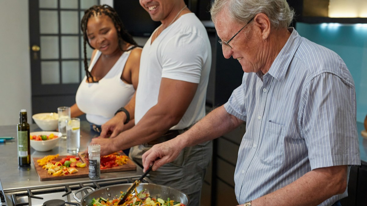 Older adults preparing a meal together in a kitchen