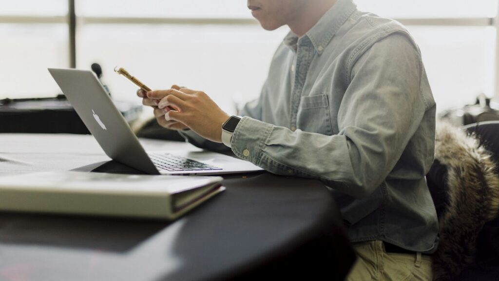 Man working at a laptop while planning time away from work.