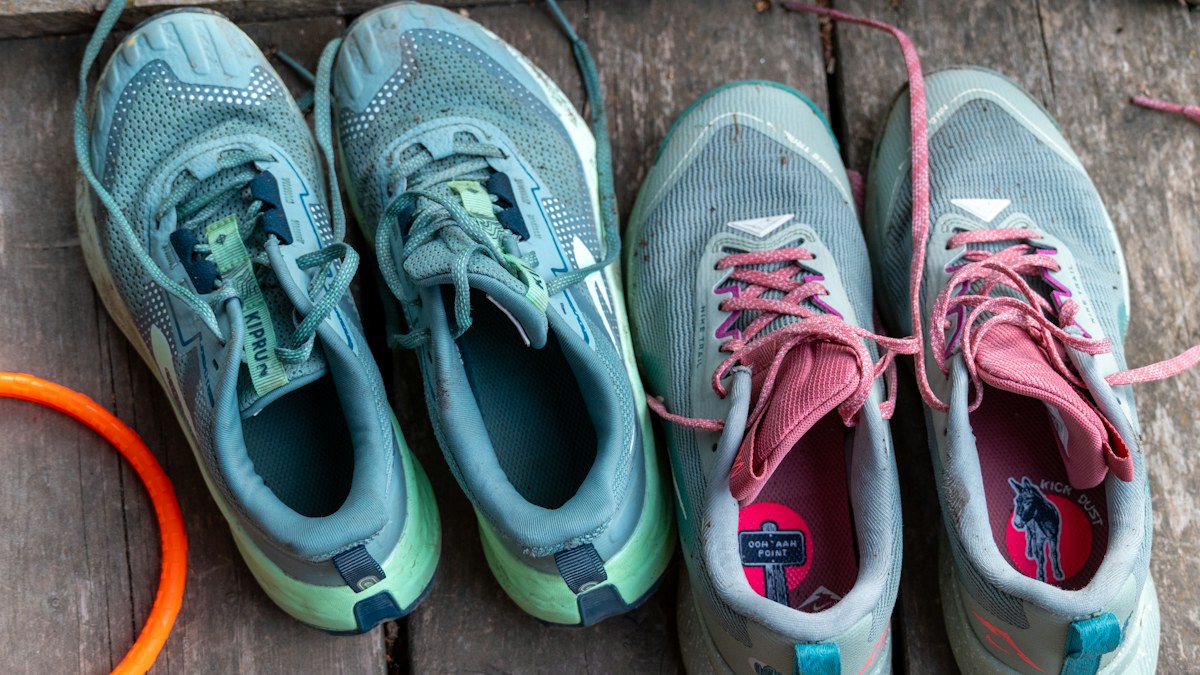 Two pairs of athletic running shoes on a wooden deck illustrating shoe rotation