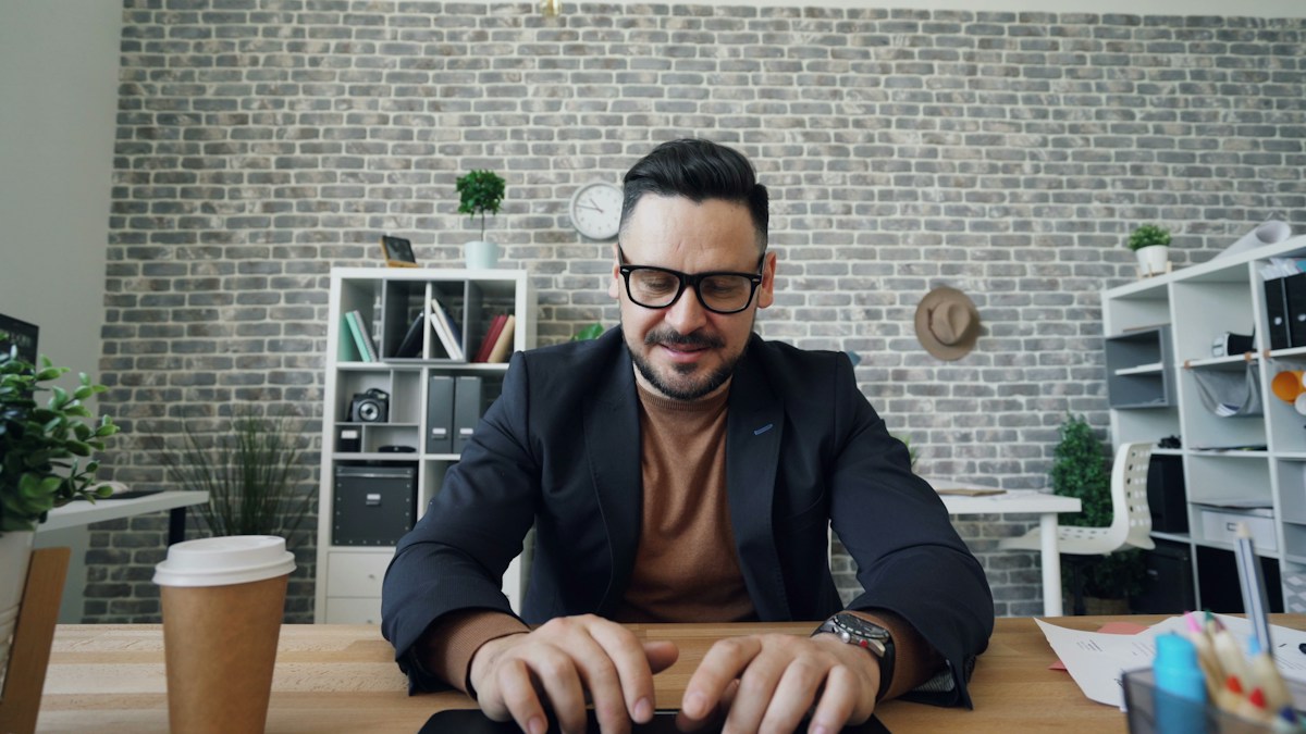 Male office worker typing an email on a laptop.